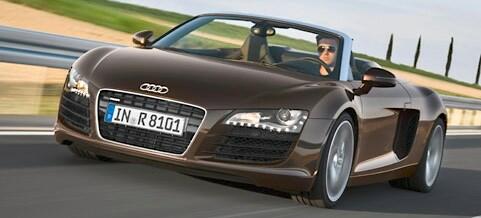 En Audi R8 Spyder kör på en väg. (AI text)