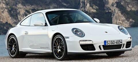 En vit Porsche 911 GTS parkerad på en strand. (AI text)