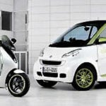 En intelligenta bil och en scootare i en parkeringsplats. (AI text)