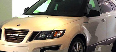 En vit bil visas i en showrum (AI text)