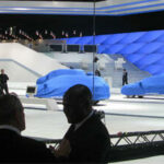 En grupp personer står framför en bil. (AI text)