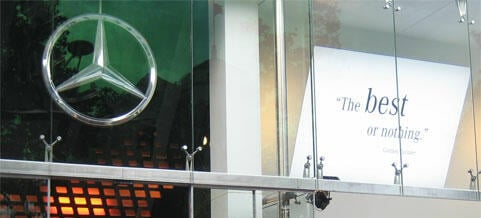 Mercedes-Benz-logotypen på ett byggnadsglas. (AI text)