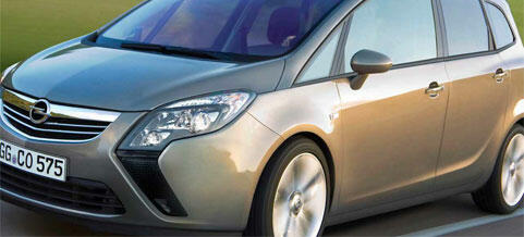 En silverfärgad Opel Astra kör längs en väg. (AI text)