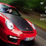 En röd sportbil kör nedför en väg med en person ombord. (AI text)