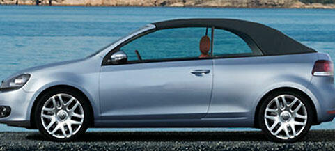 En Volkswagen Golf cabriolet parkerad på en strand. (AI text)