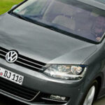 En Volkswagen Cabriolet kör nedför en landsväg. (AI text)