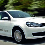 En vit Volkswagen Golf kör nedför vägen. (AI text)