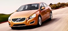 En Volvo S60 sedan kör nedför en väg. (AI text)