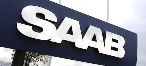 Saab-logotypen visas framför ett byggnad. (AI text)
