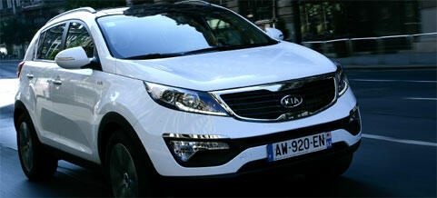 En vit SUV kör nerför en stadsgata. (AI text)