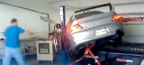 En man arbetar på en bil i en garage. (AI text)