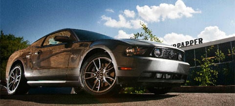 En Ford Mustang parkerad framför ett byggnad. (AI text)