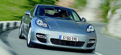 En Porsche Panamera kör nedför en snirklig väg. (AI text)