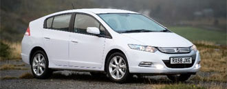 En vit Honda Insight parkerad på en grusväg. (AI text)