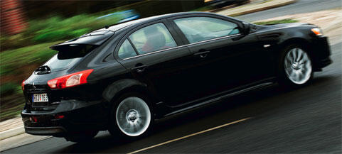 En svart bil kör nerför en gata. (AI text)