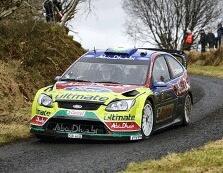 En rallybil körer längs en landsväg. (AI text)