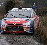 En rallybil körer längs en blöt väg. (AI text)
