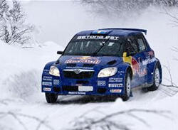 En rallybil kör genom snön. (AI text)