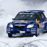 En rallybil kör genom snön. (AI text)