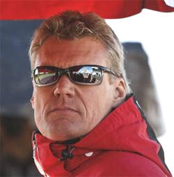 En man i ett rött jack, solglasögon på. (AI text)