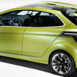 En grön bil i ett studioscenariot. (AI text)