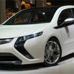 En vit bil visas upp på en bilsalong. (AI text)