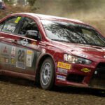 En röd rallybil kör på en grusväg. (AI text)