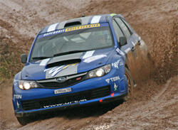 En blå Subaru WRX STI kör genom lerigt terräng. (AI text)