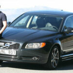 En man står bredvid en bil. (AI text)