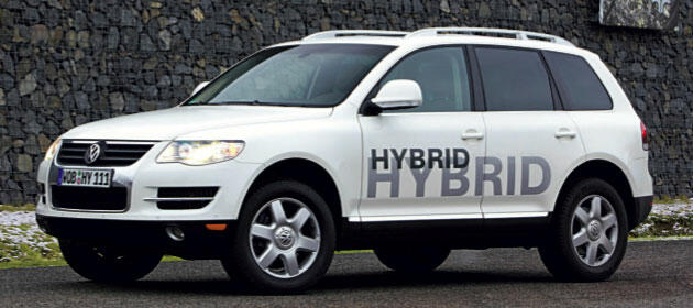 En vit Volkswagen-fyrhjulsdriven bil parkerad framför en stenmur. (AI text)