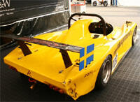 En gul racerbil parkerad i en garage. (AI text)