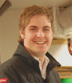 En man ler i en garage. (AI text)