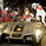 Audi R8 LMS racebil repareras av mekaniker. (AI text)