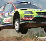 En Ford Focus rallybil i luften. (AI text)