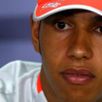 En racerbilförare i en vit mössa och vit skjorta. (AI text)