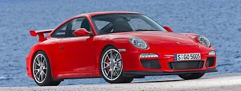 En röd Porsche 911 GTS parkerad på en strand. (AI text)