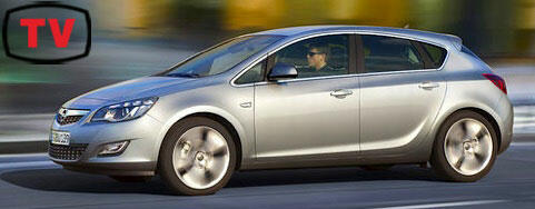 En silverfärgad Opel Astra kör ner gatan längs. (AI text)