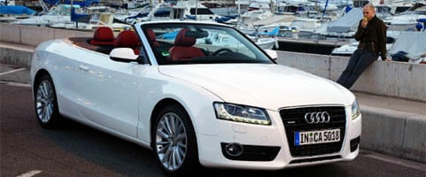 En Audi A5 cabriolet parkerad på en gata. (AI text)
