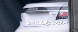 En vit bil står parkerad i ett garage. (AI text)