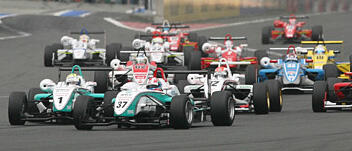 En grupp racerbilar på en bana. (AI text)