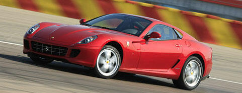 En röd Ferrari-sportbil kör på en bana. (AI text)