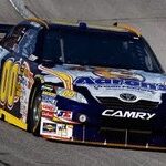 En NASCAR-bil kör längs banan. (AI text)