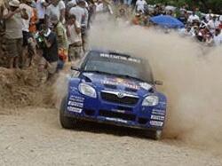 En rallybil körer nedför en stenig väg. (AI text)