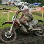 En dirtbiker cyklar genom leriga vägar. (AI text)