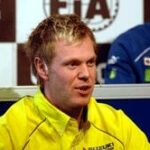 En racerförare i ett gult jack. (AI text)