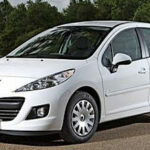 En vit bil parkerad i en skog. (AI text)