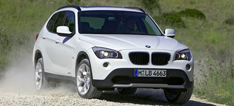 BMW X1 kör nedför en grusväg. (AI text)