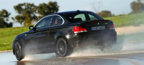 BMW X1 kör på en blöt väg (AI text)