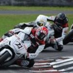 en grupp motorcykelförare på en bana (AI text)