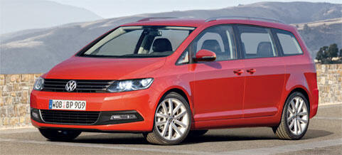 En röd Volkswagen Touran parkerad vid vägkanten. (AI text)